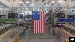 Una bandera estadounidense cuelga sobre la Terminal 1 en el Aeropuerto Internacional John F. Kennedy en Nueva York, el viernes 17 de febrero de 2023. (AP Foto/Seth Wenig)