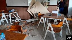 Seorang perempuan memeriksa rumah pasca gempa di Ambon, Maluku, Kamis 26 September lalu (foto: dok). Maluku utara dilanda gempa berkuatan 7,1 SR hari Jumat pagi (15/11). 