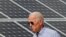 Joe Biden, yang saat itu masih kandidat presiden, berjalan melintas panel surya saat mengunjungi Insitiatif Energi Terbarukan Kawasan Plymouth, di New Hampshire, pada 4 Juni 2019. (Foto: Reuters/Brian Snyder)
