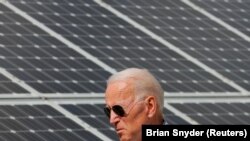 FILE PHOTO: Democratic 2020 U.S. presidential candidate and former Vice President Joe Biden walks past solar panels while touring the Plymouth Area Renewable Energy Initiative in Plymouth, New Hampshire, U.S., June 4, 2019. REUTERS/Brian Snyder/File Photo