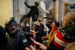 FILE - Pro-Trump protesters storm the U.S. Capitol to contest the certification of the 2020 U.S. presidential election results by Congress, in Washington, Jan. 6, 2021.