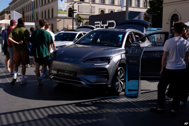 FILE - Visitors watch a BYD Seal U car at the IAA motor show in Munich, Germany, Friday, Sept. 8, 2023. (AP Photo/Matthias Schrader, File)