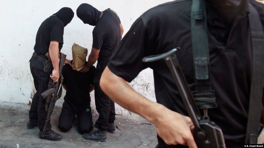 Chiến binh Hamas bắt một người tình nghi làm việc cho Israel tại thành phố Gaza. 