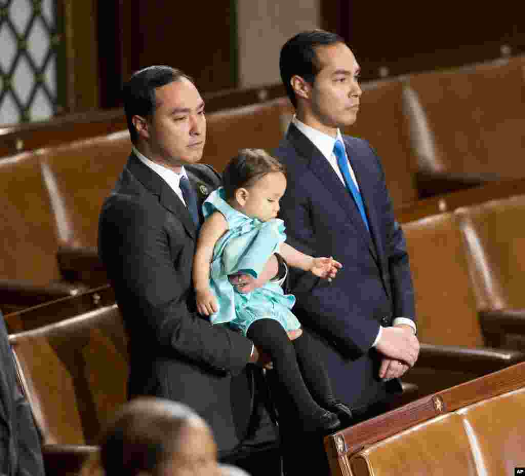 Rep. Joaquin Castro, D-Texas holds his daughter, Andrea Elena Castro, as he stands with his brother, Housing and Urban Development Secretary Julian Castro as they join other members of the House of Representatives for the opening session of the 114th Congress, Washington, Jan. 6, 2015.