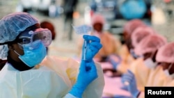 FILE - A health worker fills a syringe with Ebola vaccine before injecting it into a patient, in Goma, Democratic Republic of Congo, Aug. 5, 2019.