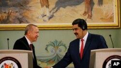 Presiden Venezuela Nicolas Maduro (kanan) berjabat atngan dengan Presiden Turki Recep Tayyip Erdogan di Istana Presiden Miraflores, Caracas, Venezuela, 3 Desember 2018. (Foto: dok)