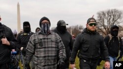 In this Jan. 6, 2021, photo, Proud Boy members Joseph Biggs, left, and Ethan Nordean, right with megaphone, walk toward the U.S. Capitol in Washington.