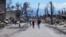 Unas personas caminan por una calle ante los daños causados por un incendio forestal, el viernes 11 de agosto de 2023, en Lahaina, Hawái.