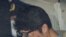 Takahiro Shiraishi covers his face inside a police car in Tokyo, in this photo taken by Kyodo November 2017 and released by Kyodo, Dec. 15, 2020.