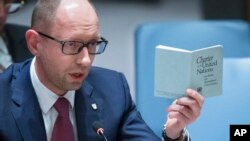 Perdana Menteri sementara Ukraina Arseniy Yatsenyuk berbicara di Dewan Keamanan PBB di New York sambil memegang buku perjanjian PBB (13/3). (AP/John Minchillo)