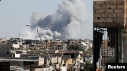 Smoke rises near the stadium where the Islamic State militants are holed up after an air strike by coalition forces at the frontline, in Raqqa, Oct. 12, 2017. 