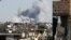 Smoke rises near the stadium where the Islamic State militants are holed up after an air strike by coalition forces at the frontline, in Raqqa, Oct. 12, 2017. 