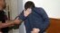 FILE - A 19-year-old dual U.S.-Israeli citizen covers his face as he is brought to court in Rishon Lezion, Israel, March 23, 2017. Israeli police said they have arrested a Jewish Israeli man who is the prime suspect behind a wave of bomb threats against Jewish community centers and other institutions in the United States. 