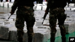 FILE - Police officers stand guard over seized cocaine they present to the press.