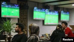 FILE - Iranian women watch a football match at a cafe in Tehran, Iran, Sept. 15, 2019. 