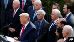 FILE - President Donald Trump with Vice President Mike Pence, left, and members of the president's coronavirus task force speaks during a news conference at the Brady press briefing room of the White House, Feb. 26, 2020, in Washington.