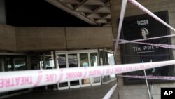 FILE - Britain's National Theatre is dressed in tape at the launch of the #MissingLiveTheatre campaign by UK theater designers on the south bank of the River Thames in London, July 3, 2020.