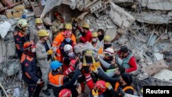Tim penyelamat mengangkat Rabia Ofkeli (27 tahun) dari reruntuhan puing-puing bangunan yang hancur akibat gempa di Hatay, Turki, 10 Februari 2023. (REUTERS/Kemal Aslan)