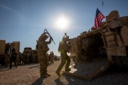 Crewmen enter Bradley fighting vehicles at a US military base at an undisclosed location in northeastern Syria, Nov. 11, 2019.