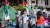 Dos estudiantes conversan en un campamento de protesta a favor de los palestinos, el lunes 22 de abril de 2024, en la Universidad de Columbia, en Nueva York. (AP Foto/Stefan Jeremiah)