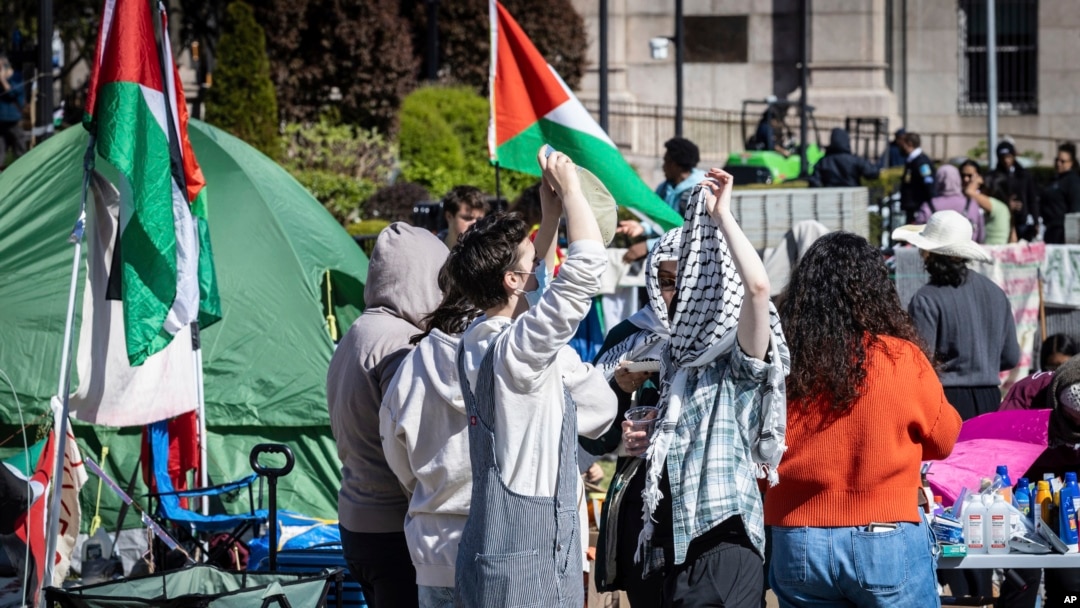 Dos estudiantes conversan en un campamento de protesta a favor de los palestinos, el lunes 22 de abril de 2024, en la Universidad de Columbia, en Nueva York. (AP Foto/Stefan Jeremiah)