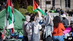 Dos estudiantes conversan en un campamento de protesta a favor de los palestinos, el lunes 22 de abril de 2024, en la Universidad de Columbia, en Nueva York. (AP Foto/Stefan Jeremiah)