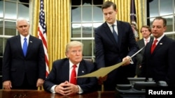 En esta fotografía de archivo, el Secretario del Personal de la Casa Blanca, Rob Porter (segundo desde la derecha) entrega al Presidente Donald Trump, un documento para confirmar al secretario de Defensa, James Mattis, el 20 de enero de 2017. Porter renunció el miércoles 7 de febrero de 2018 tras revelarse acusaciones de golpeó y maltrató a sus dos ex esposas.