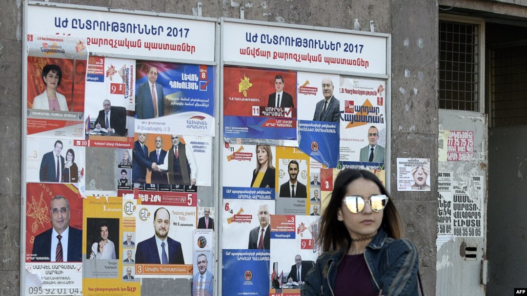 A woman walks past election posters on March 29, 2017 in Yerevan, ahead of April 2 parliamentary elections.