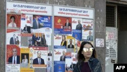 A woman walks past election posters on March 29, 2017 in Yerevan, ahead of April 2 parliamentary elections.