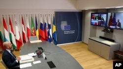 European Council President Charles Michel, left, speaks with Chinese Premier Li Keqiang, on screen, during an EU-China summit, in video conference format, at the European Council in Brussels, Monday, June 22, 2020. (Yves Herman, Pool Photo via AP)