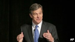 FILE - Roy Cooper speaks during a forum in Charlotte, N.C.