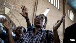 Une femme chante et danse lors d'une messe en mémoire des victimes de la répression de la marche du mois dernier à Kinshasa, le 12 janvier 2018.