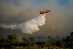 An aircraft dumps water on a wildfire near Le Luc, southern France, Aug. 17, 2021.