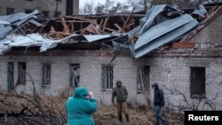 Residents walk at a site of a Russian missile strike, amid Russia's attack on Ukraine, in Dnipro, Ukraine, Nov. 21, 2024. 