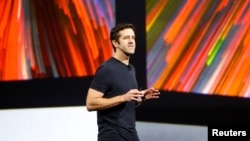 资料照片：约翰·特努斯在加利福尼亚州圣何塞举行的苹果年度全球开发者大会上发言。(2017年6月5日)