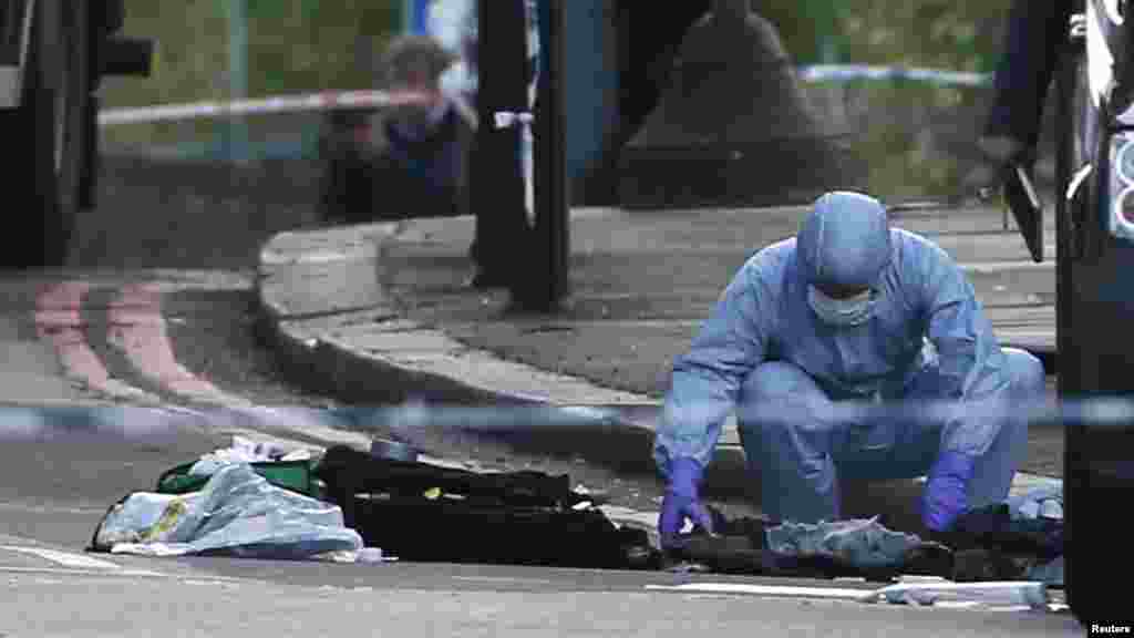 A police forensics officer investigates a crime scene where one man was killed in Woolwich, southeast London May 22, 2013.