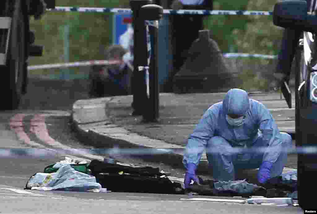 A police forensics officer investigates a crime scene where one man was killed in Woolwich, southeast London May 22, 2013.