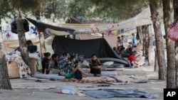 FILE - Displaced Iraqis from the Yazidi community gather at a park near the Turkey-Iraq border at the Ibrahim al-Khalil crossing on Aug. 15, 2014. 