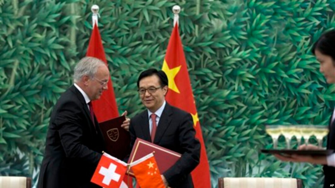Menteri Perdagangan China, Gao Hucheng, dan Menteri Ekonomi Swiss, Johann Schneider-Ammann menandatangani kesepakatan perdagangan bebas di Beijing, Sabtu (6/7).