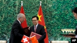 Menteri Perdagangan China, Gao Hucheng, dan Menteri Ekonomi Swiss, Johann Schneider-Ammann menandatangani kesepakatan perdagangan bebas di Beijing, Sabtu (6/7).