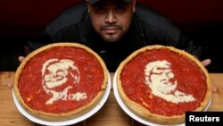 El cocinero Fabián Martínez posa con pizzas decoradas con imágenes de Hillary Clinton y Donald Trump en Giordano' Pizzeria, en Chicago, Illinois.