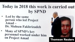  بنیامین نتانیاهو، نخست وزیر اسرائیل، در یک کنفرانس خبری در وزارت دفاع در تل آویو ۳۰ آوریل ۲۰۱۸، به صفحه‌ای با تصویر محسن فخری‌زاده، دانشمند هسته‌ای ایران، اشاره می‌کند.
