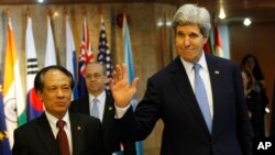 Menlu AS John Kerry (kanan), melambaikan tangan ke arah para wartawan seusai pertemuan dengan Sekjen ASEAN, Le Luong Minh (kiri) di Kantor Pusat ASEAN di Jakarta (16/2).