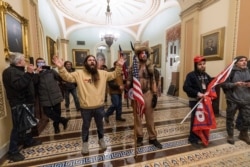 Supporters of President Donald Trump are confronted by U.S. Capitol Police officers outside the Senate Chamber inside the Capitol in Washington, Jan. 6, 2021.