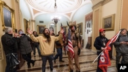 FILE - Supporters of President Donald Trump are confronted by U.S. Capitol Police officers outside the Senate Chamber inside the Capitol in Washington, Jan. 6, 2021.