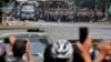 FILE - Police stand on a road during an anti-coup protest in Mandalay, Myanmar, March 3, 2021.