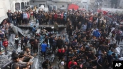 Palestinians look at the destruction after an Israeli strike in Rafah, Gaza, on Dec. 20, 2023. The Israel-Hamas war entered its 75th day as the U.N. Security Council postponed for another day a vote on a resolution to increase aid deliveries to Gaza.