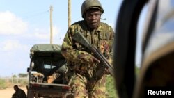 FILE - A Kenya Defense Force soldier runs for cover near the perimeter wall where al-Shabab attackers have holed up at a campus in Garissa, Kenya, April 2, 2015. Five Kenyan police officers are dead after suspected Islamist al-Shabab militants attacked a police convoy as it traveled through the northeastern part of the country, a local official said.