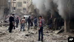 Syrians try to extinguish a fire after an aerial bombardment, blamed on the Assad government, on the Damascus suburb of Douma. The Douma Revolution News Network published the image on its Facebook page Dec. 13, 2015. 