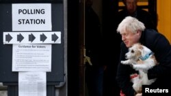 Perdana Menteri Boris Johnson meninggalkan tempat pemungutan suara di Methodist Central Hall bersama anjingnya, Dilyn, setelah melaksanakan hak pilih pada pemilu di London, Inggris, 12 Desember 2019. 